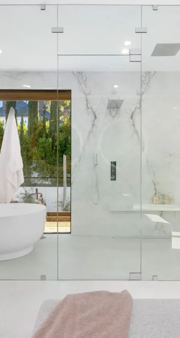 Spacious bathroom with a bathtub behind glass panels A spacious bathroom with a bathtub behind glass panels
