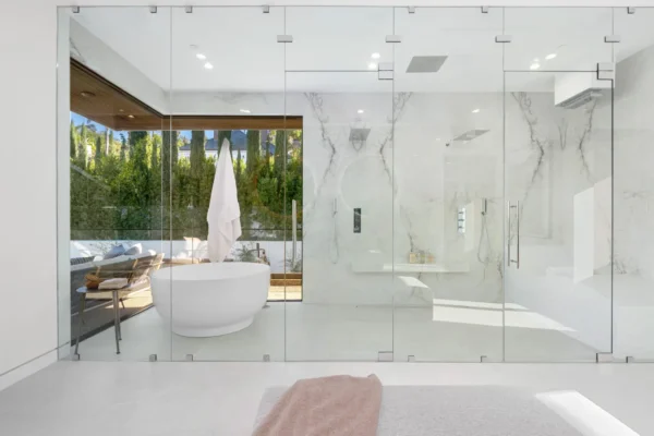 Spacious bathroom with a bathtub behind glass panels A spacious bathroom with a bathtub behind glass panels
