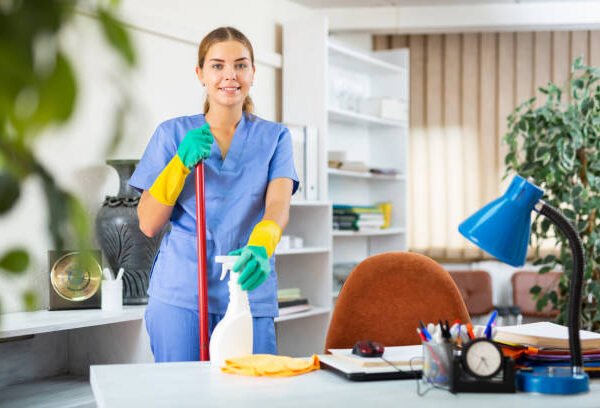 istockphoto-1350701180-612x612 Young woman in surgical scrubs cleaning floor. She's using mop and rubber gloves.