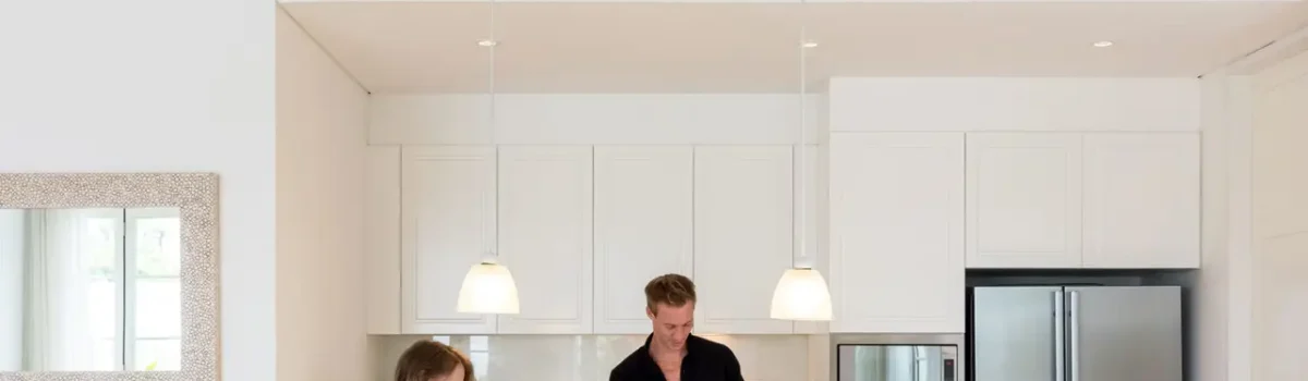 Couple making lunch on a white island kitchen at home