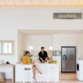 Couple cooking on a white kitchen at home Couple making lunch on a white island kitchen at home