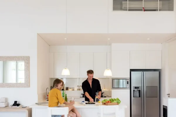 Couple cooking on a white kitchen at home Couple making lunch on a white island kitchen at home